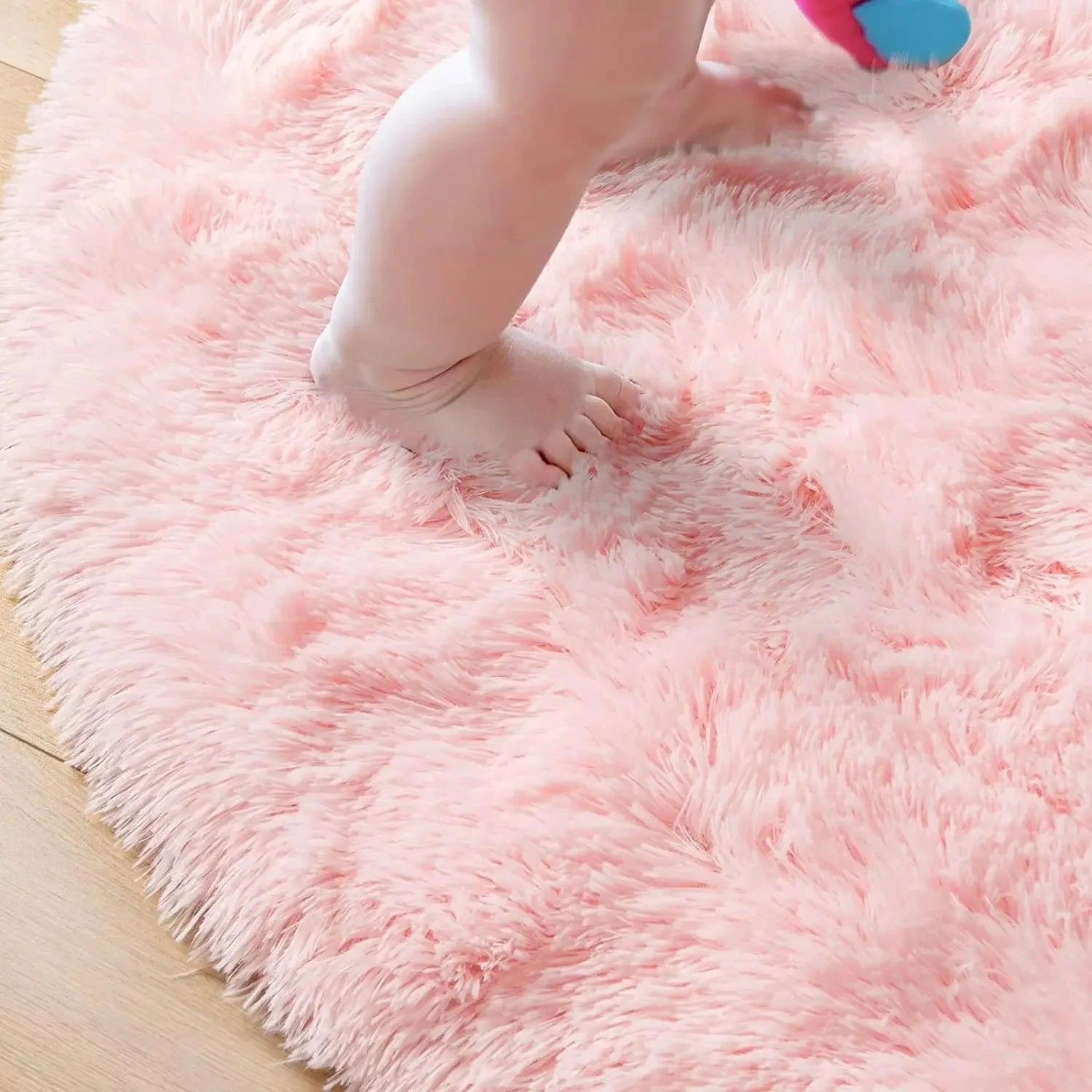 Pieds nus enfoncés dans le poil long de 4,5 cm du tapis rond rose