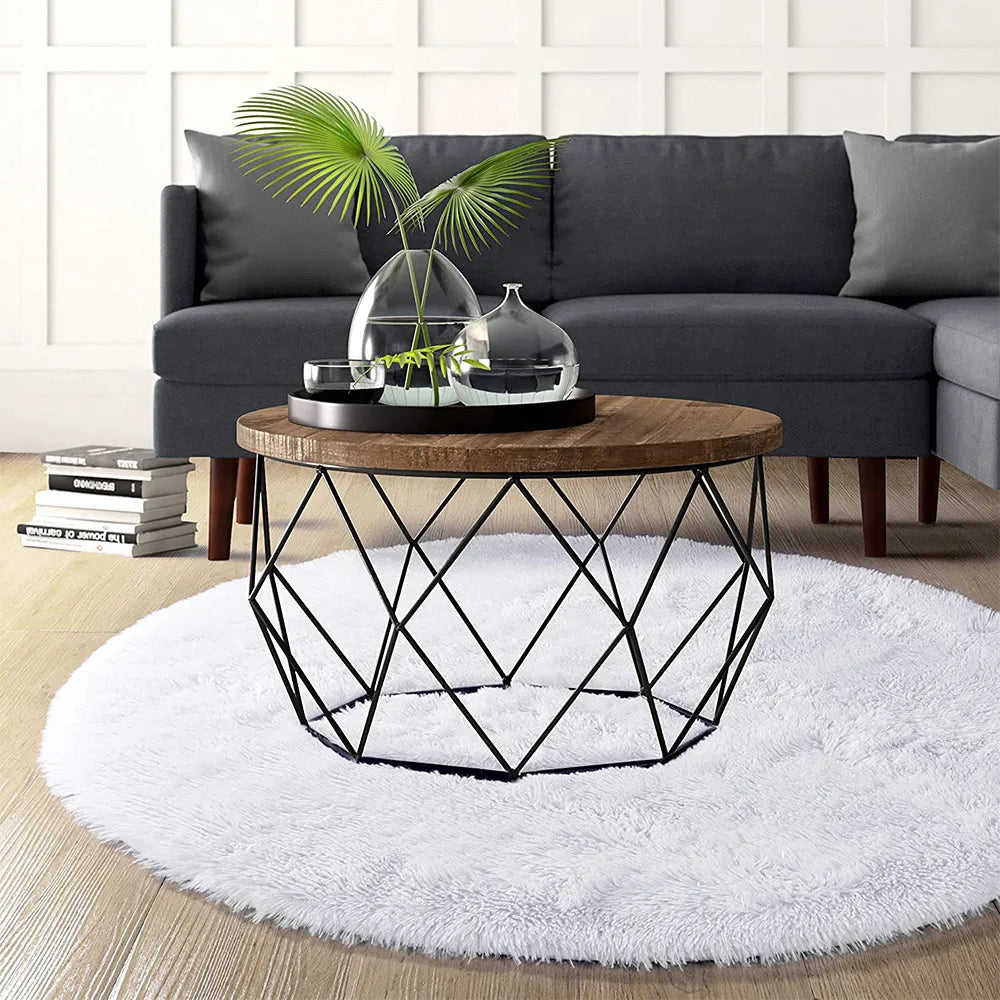 Tapis rond blanc dans un salon avec canapé gris foncé et table basse géométrique noire
