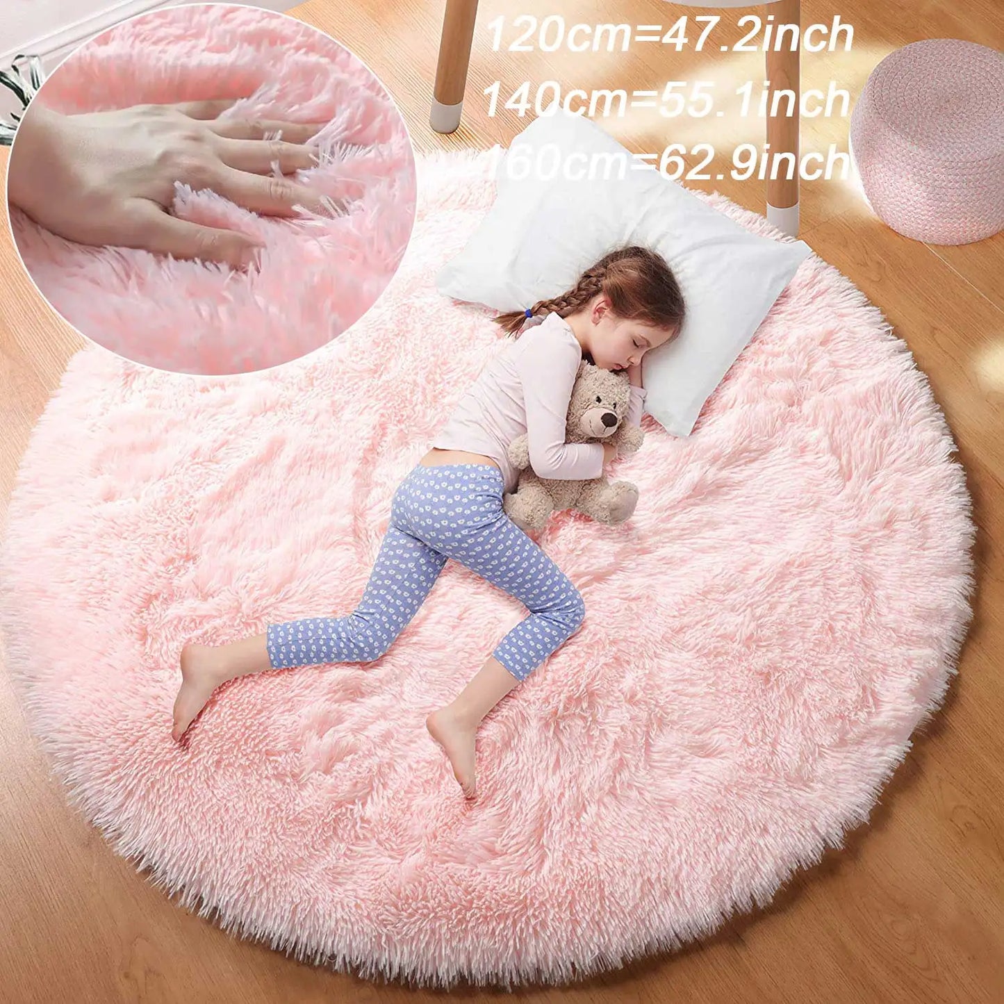 Fillette qui dort avec un ours en peluche sur un tapis rond rose poil long, encart de la main qui s'enfonce dans le poil