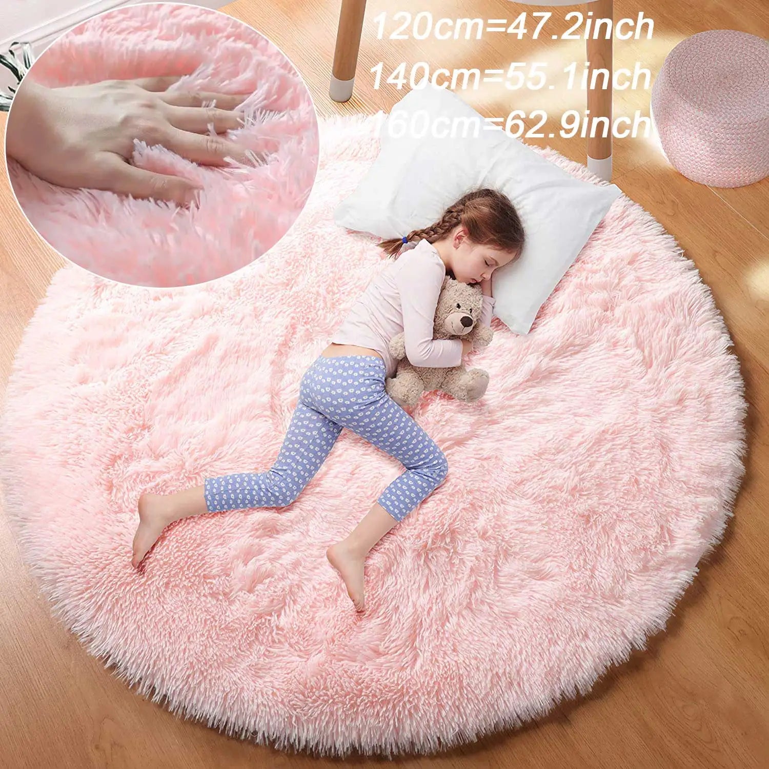 Fillette qui dort avec un ours en peluche sur un tapis rond rose poil long, encart de la main qui s'enfonce dans le poil