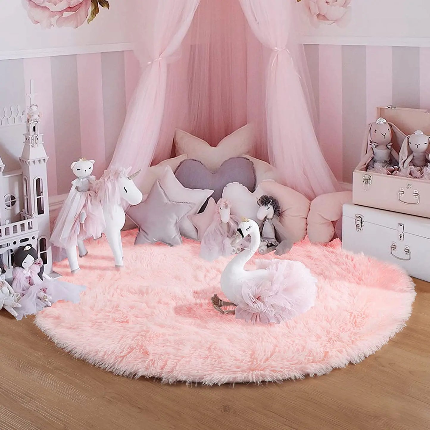 Tapis rond rose poil long sous un ciel de lit en chambre fillette avec licorne, cygne et peluches