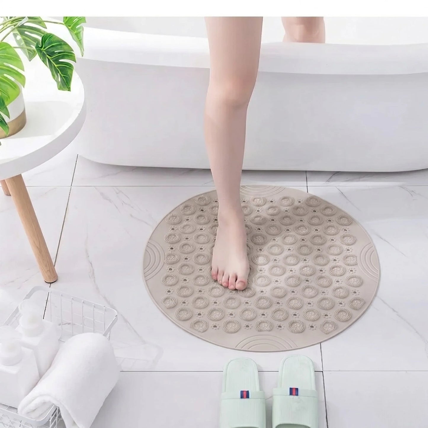 Pieds sur tapis rond beige de bain, gros plan picots massants en PVC