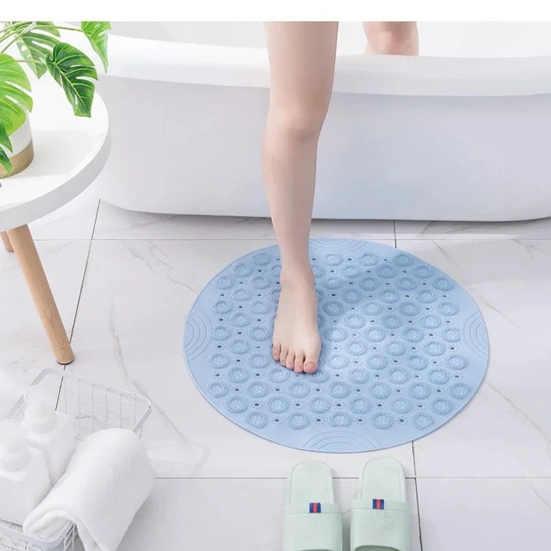 Tapis rond bain bleu posé à la sortie de douche dans une salle de bain claire