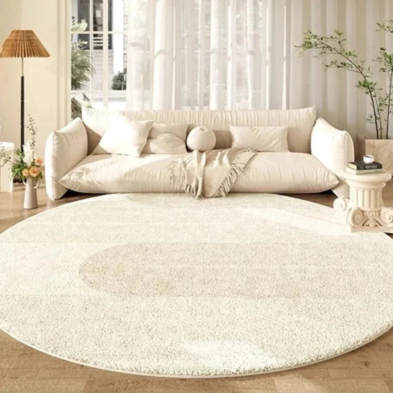 Tapis rond beige motif demi-cercle dans un salon lumineux avec canapé crème nuage, lampadaire rotin et grandes fenêtres