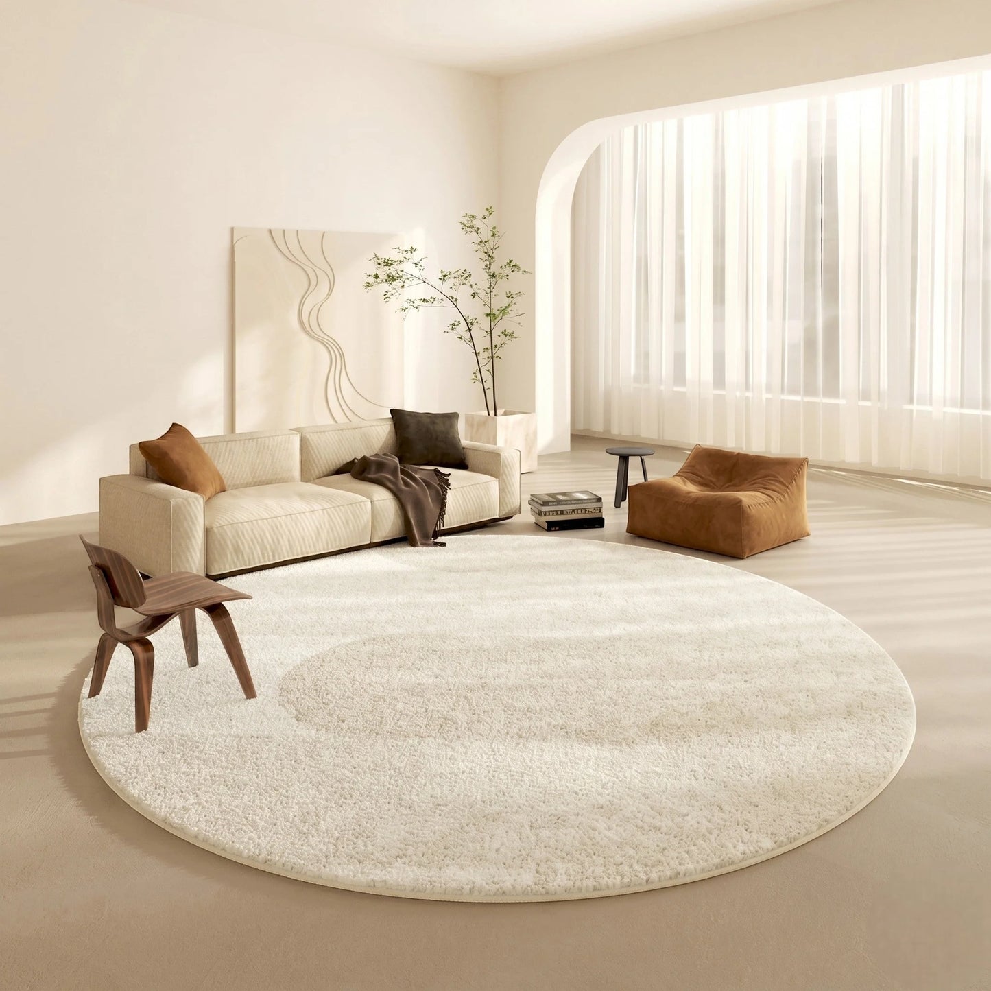 Tapis rond beige motif demi-cercle dans un salon clair avec canapé crème, pouf cognac et chaise plywood devant une fenêtre arquée voilée