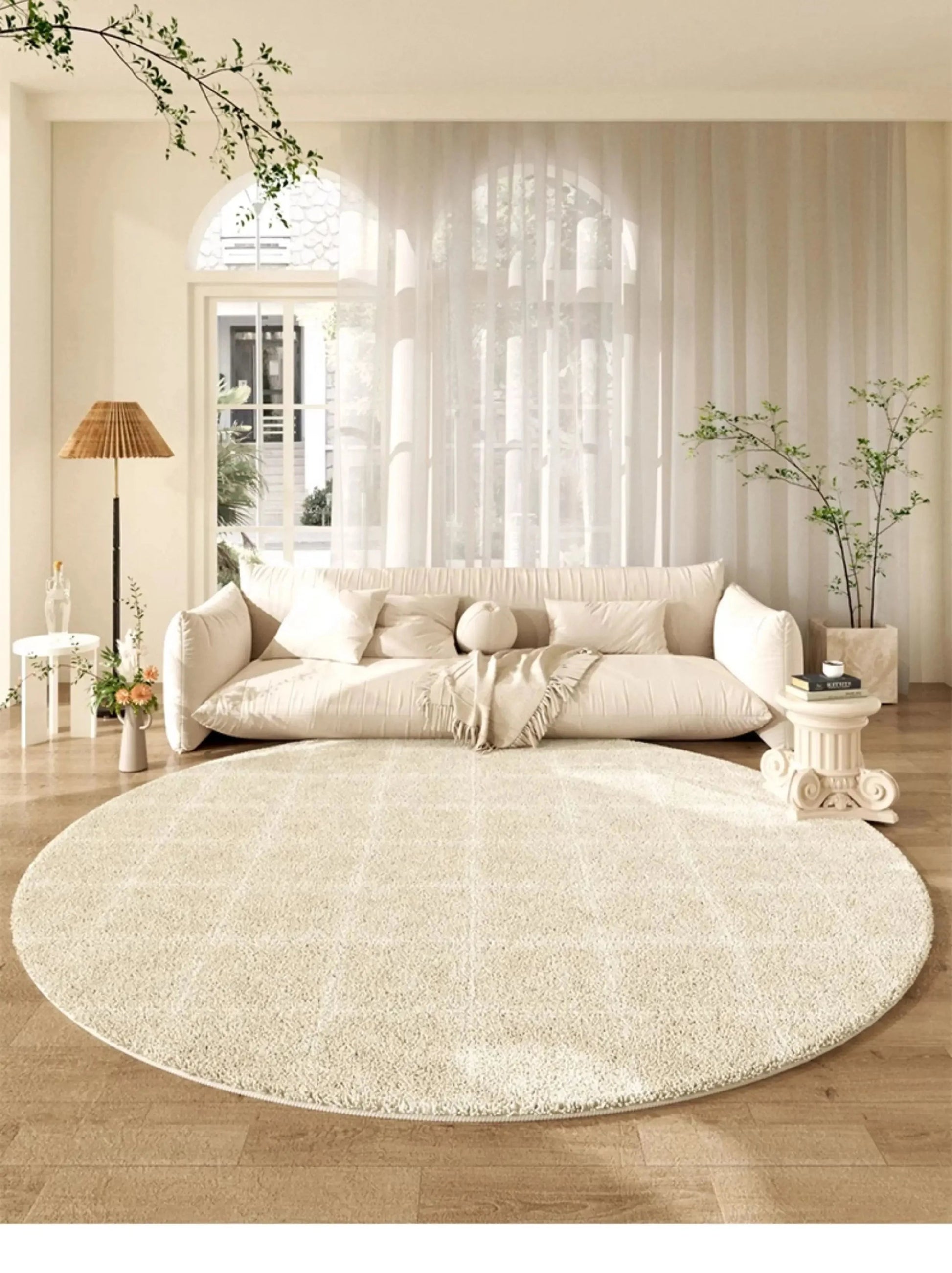 Tapis rond beige grille géométrique dans un grand salon lumineux avec canapé crème nuage et fenêtres arquées