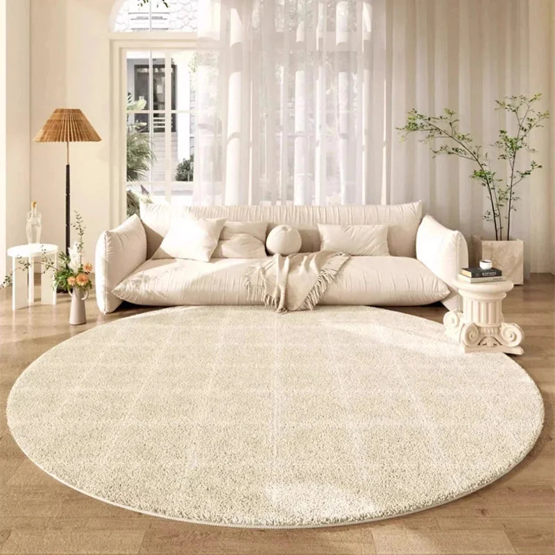 Tapis rond beige grille géométrique dans un salon lumineux avec canapé crème nuage, lampe rotin et baie vitrée