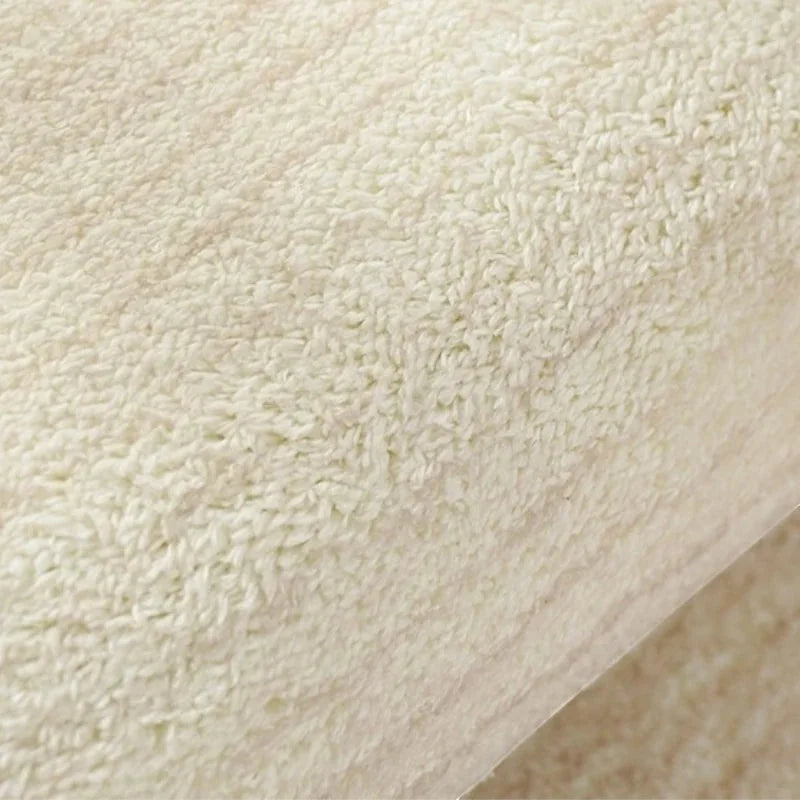 Vue macro des fibres denses du tapis rond beige motif vagues en polyester tissé Wilton