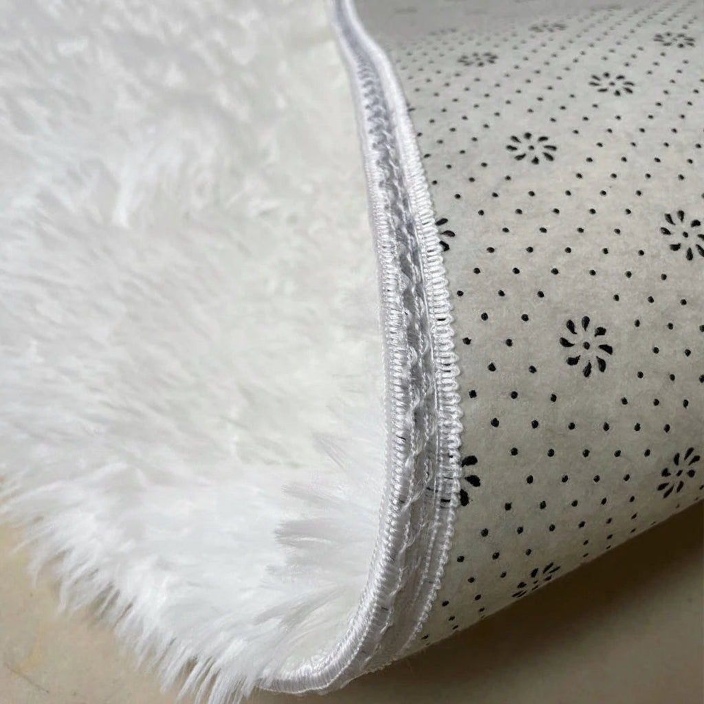 Vue rapprochée de la sous-face antidérapante à motifs en pastilles d'un tapis rond blanc
