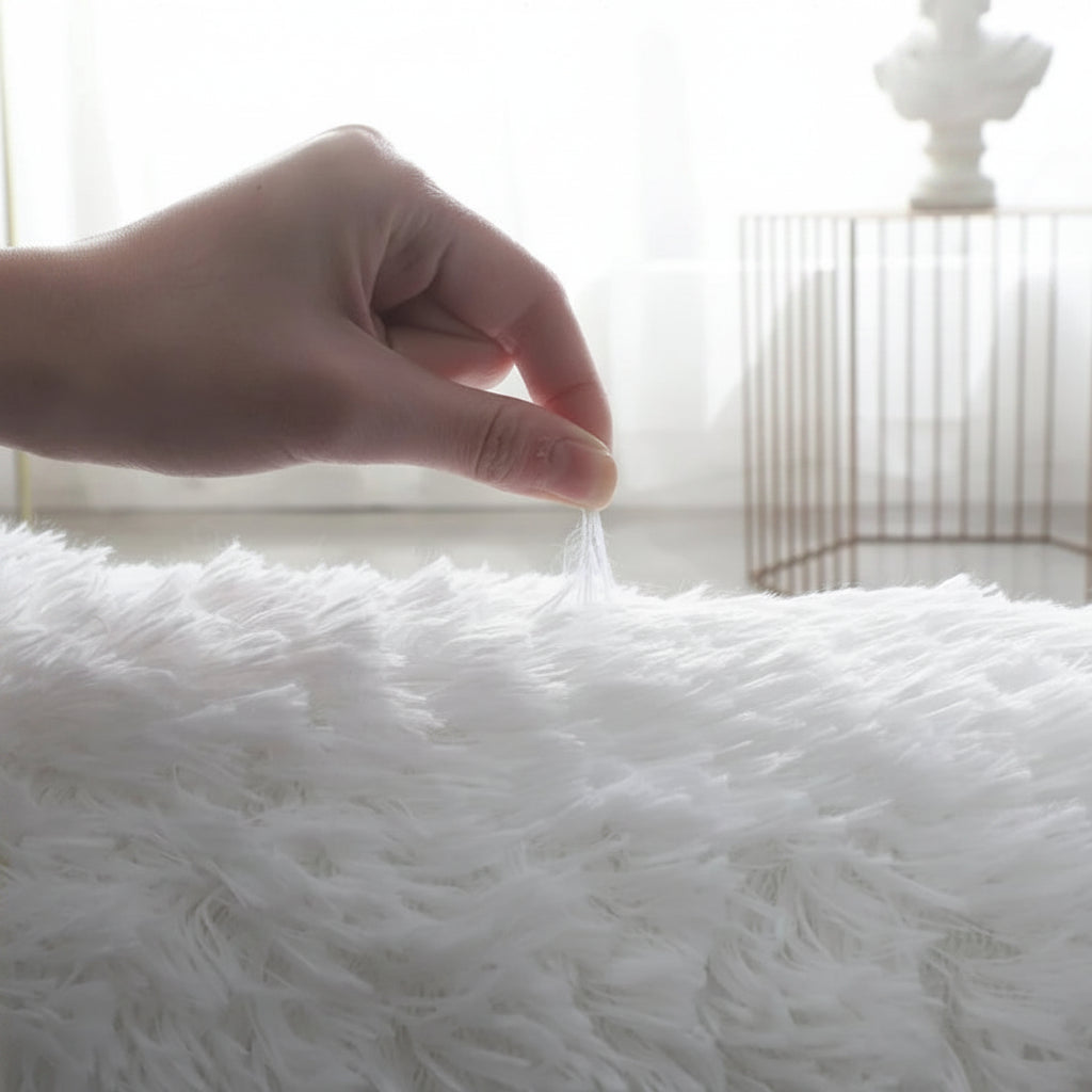 Démonstration de la tenue des fibres, main pinçant un brin de poil long blanc