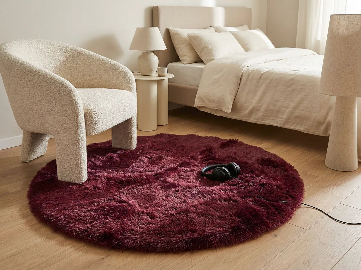 Tapis rond chambre moelleux bordeaux sous un fauteuil dans un coin lecture de la chambre
