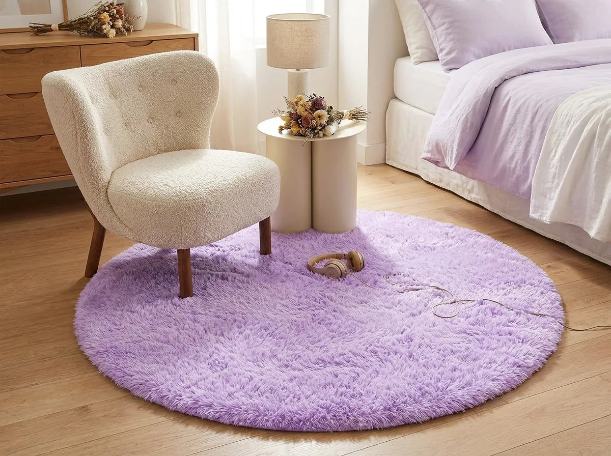 Tapis rond chambre moelleux mauve sous un fauteuil dans un coin lecture de la chambre