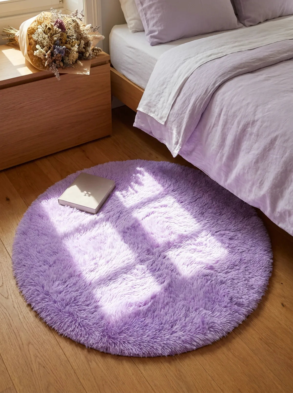 Tapis rond chambre moelleux mauve en descente de lit dans une chambre à la note florale