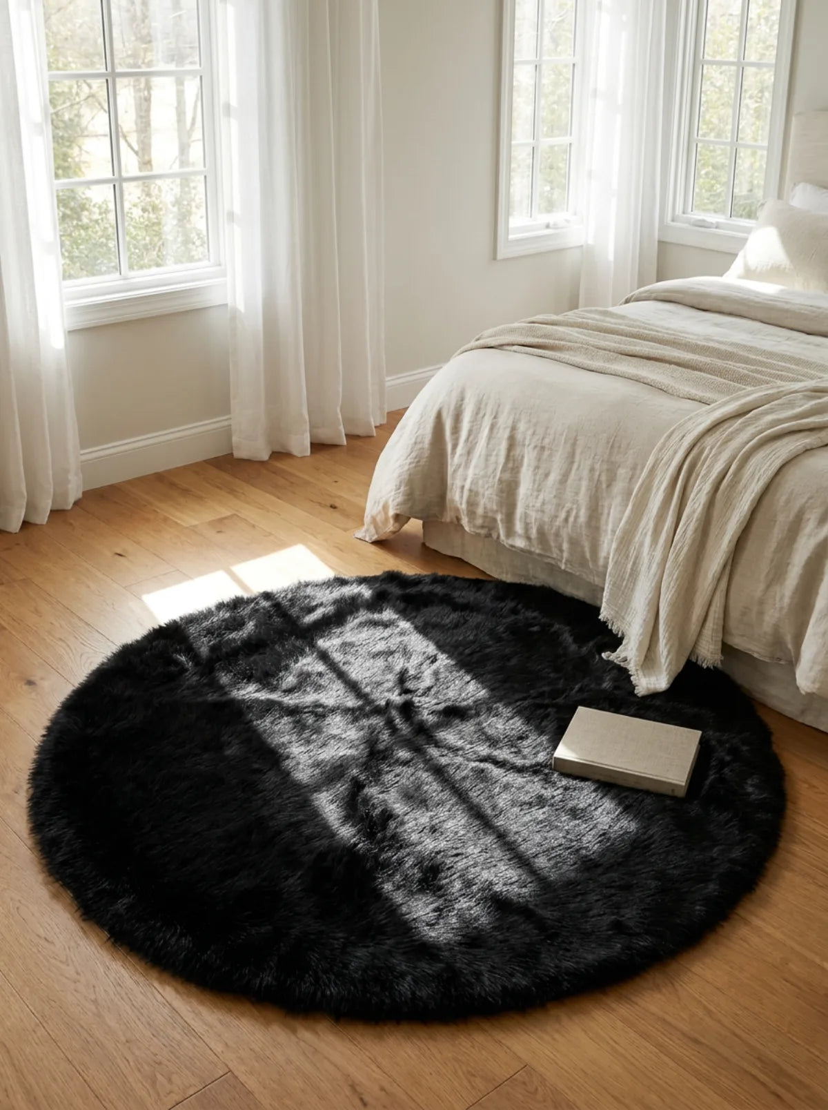 Tapis rond chambre moelleux noir en descente de lit dans une chambre lumineuse