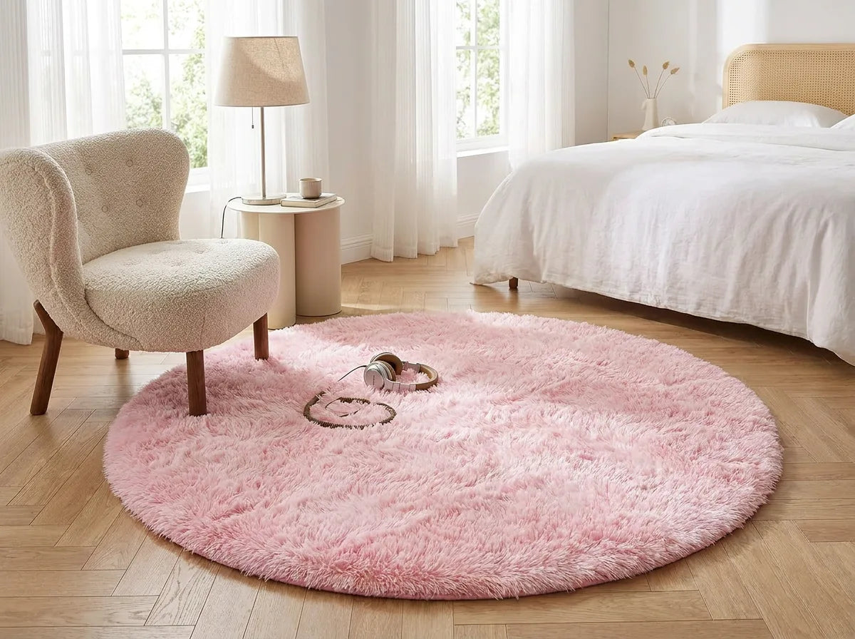 Tapis rond chambre moelleux rose pâle sous un fauteuil dans un coin lecture de la chambre