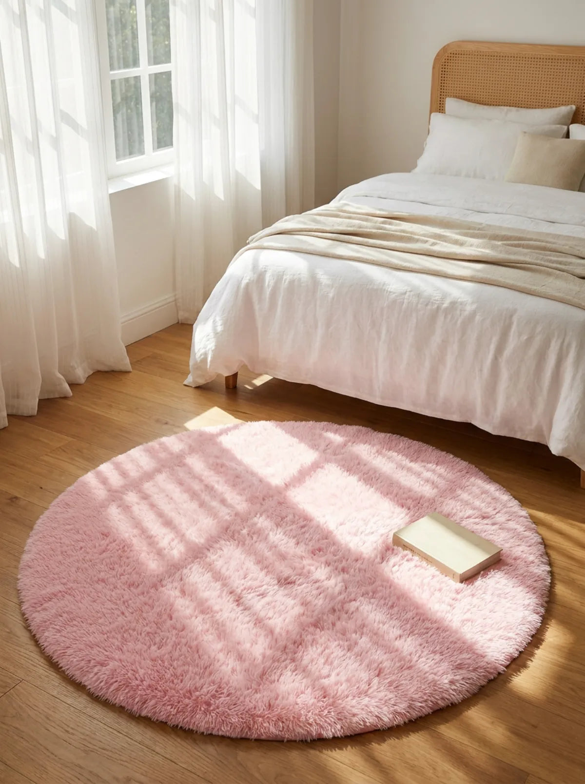 Tapis rond chambre moelleux rose pâle en descente de lit dans une chambre claire