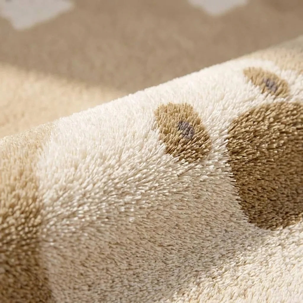 Macro de la peluche du tapis rond enfant ours nuages, détail du motif et de la texture