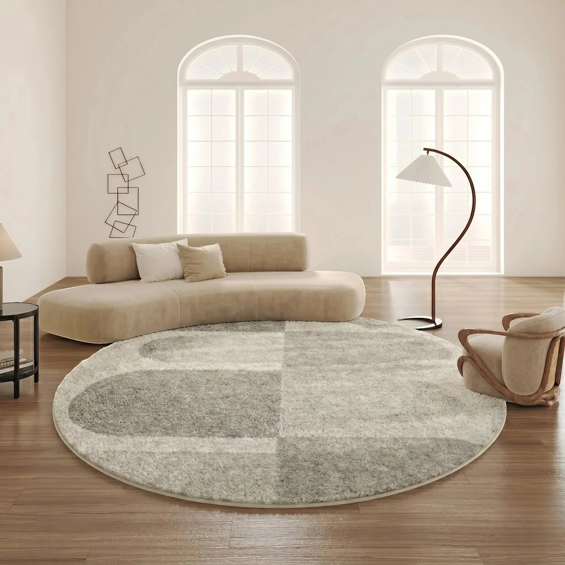 Tapis rond gris tracé organique dans un grand salon loft lumineux avec canapé courbe crème et fauteuil cannage