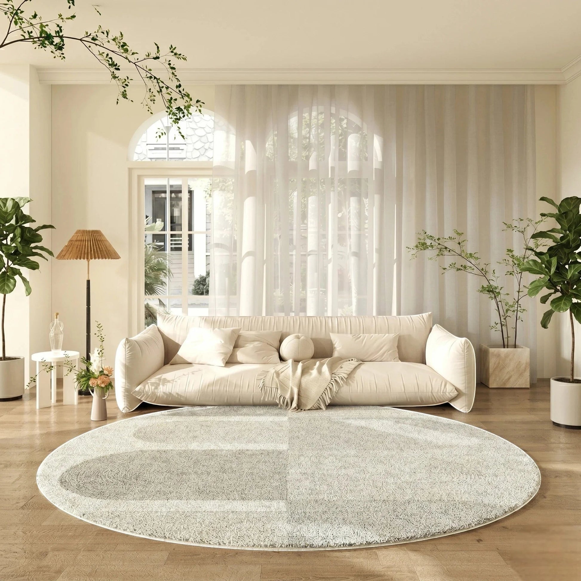 Tapis rond gris clair tracé organique dans un salon lumineux avec canapé crème et grande baie vitrée arquée