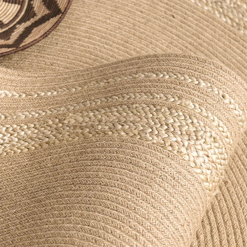 Détail rapproché des bandes contrastées du tapis rond en jute tressé anneaux écru