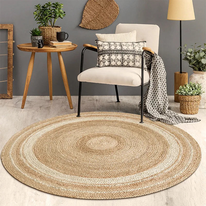 Tapis rond en jute tressé anneaux écru posé dans un salon avec fauteuil blanc et table d'appoint en bois