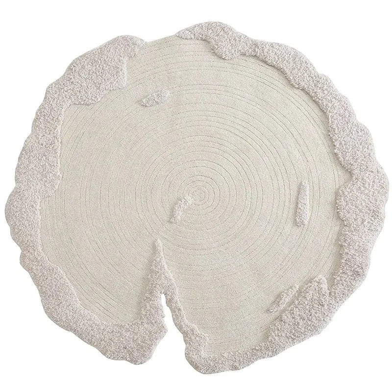 Vue studio du tapis rond laine écru aux bords organiques tressés main
