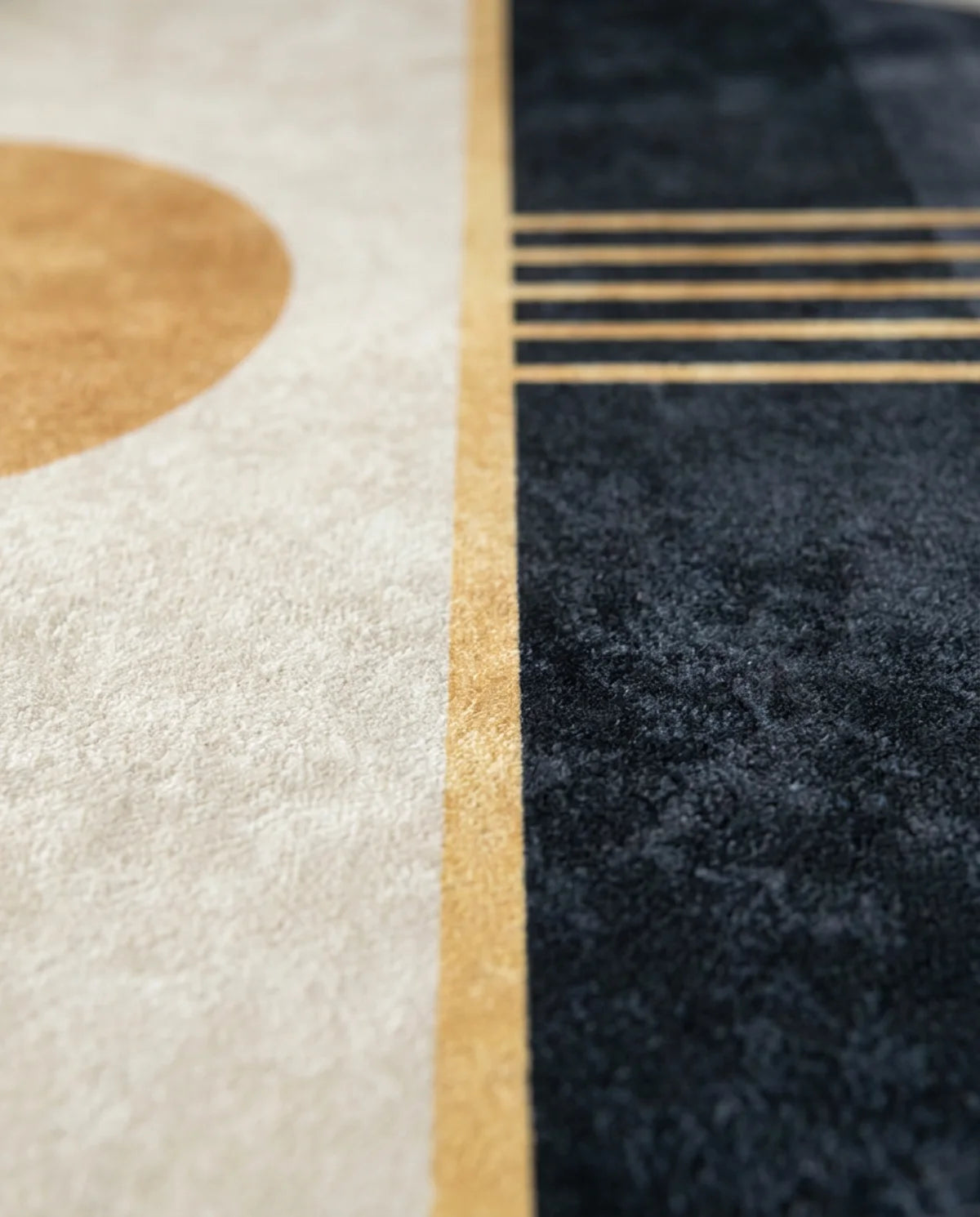 Détail des rayures dorées du tapis rond lavable crème et noir