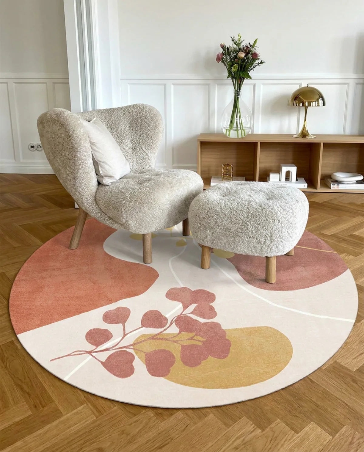 Tapis rond lavable en machine eucalyptus terracotta sous un fauteuil bouclette, salon parquet chevron