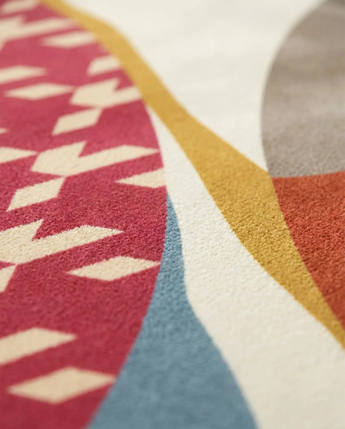 Détail du pied-de-coq framboise du tapis rond lavable patchwork corail