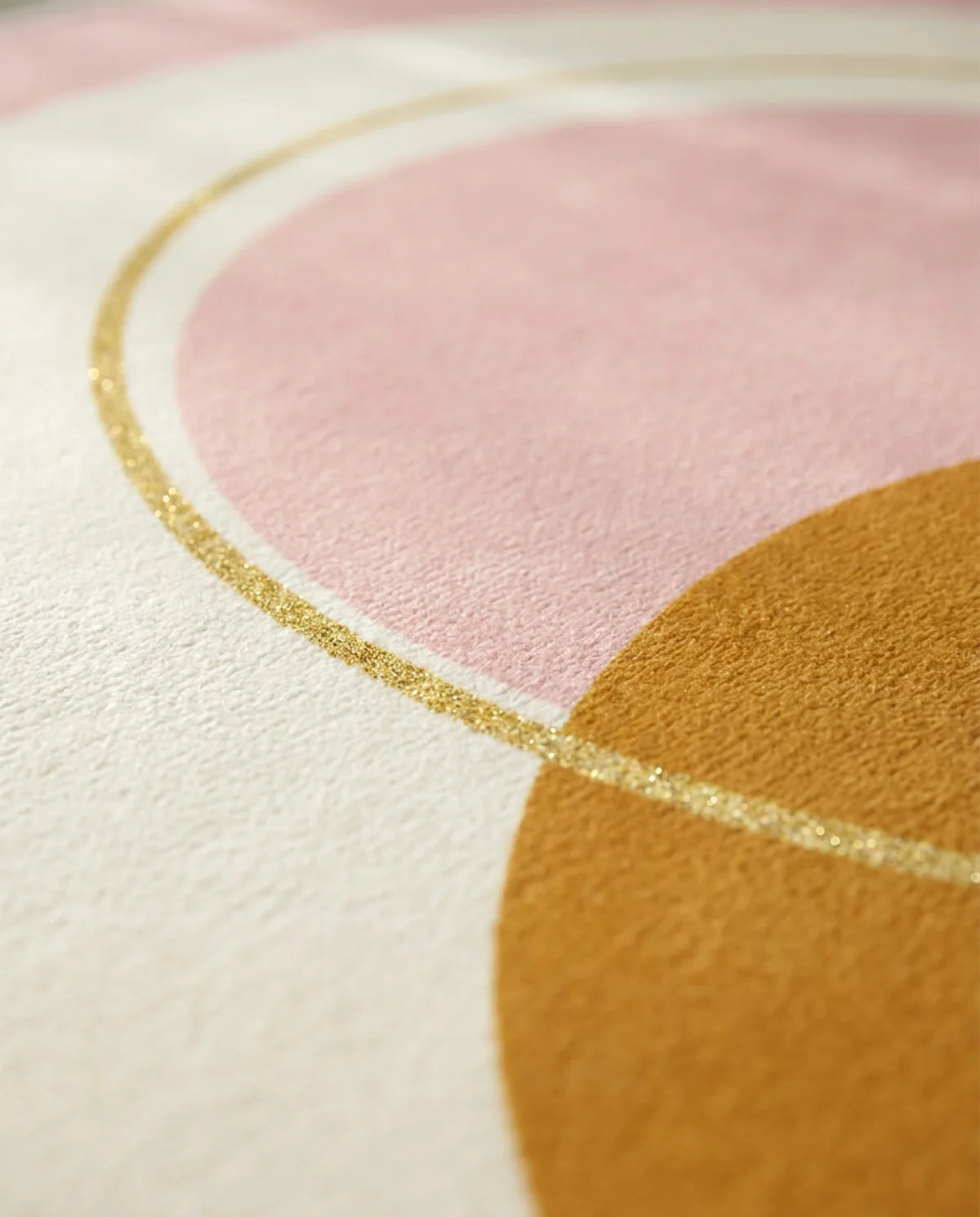 Détail de l'anneau doré du tapis rond lavable rose cercles dorés