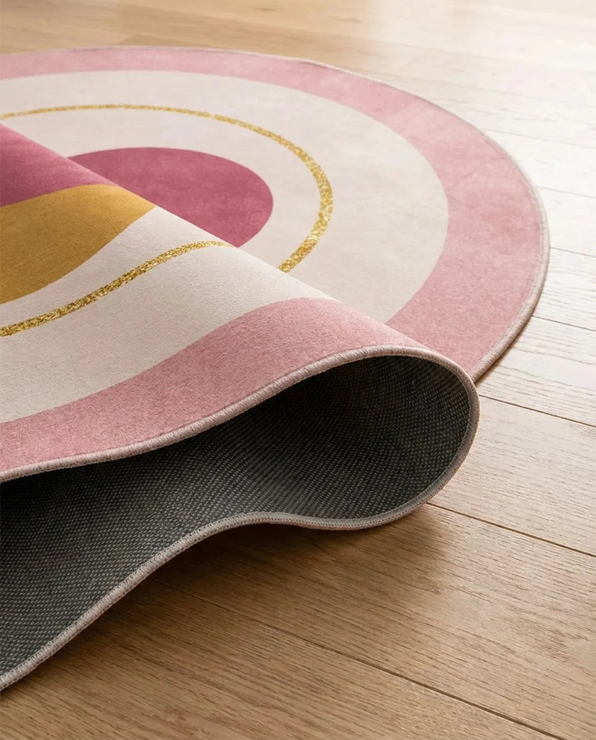 Profil fin et sous-face antidérapante du tapis rond lavable rose cercles dorés