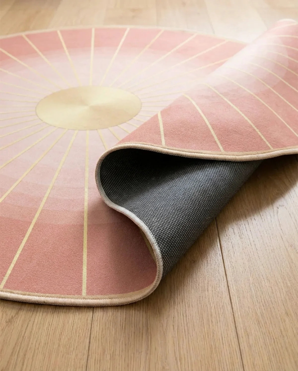 Profil fin et sous-face antidérapante du tapis rond lavable rose rayons de soleil