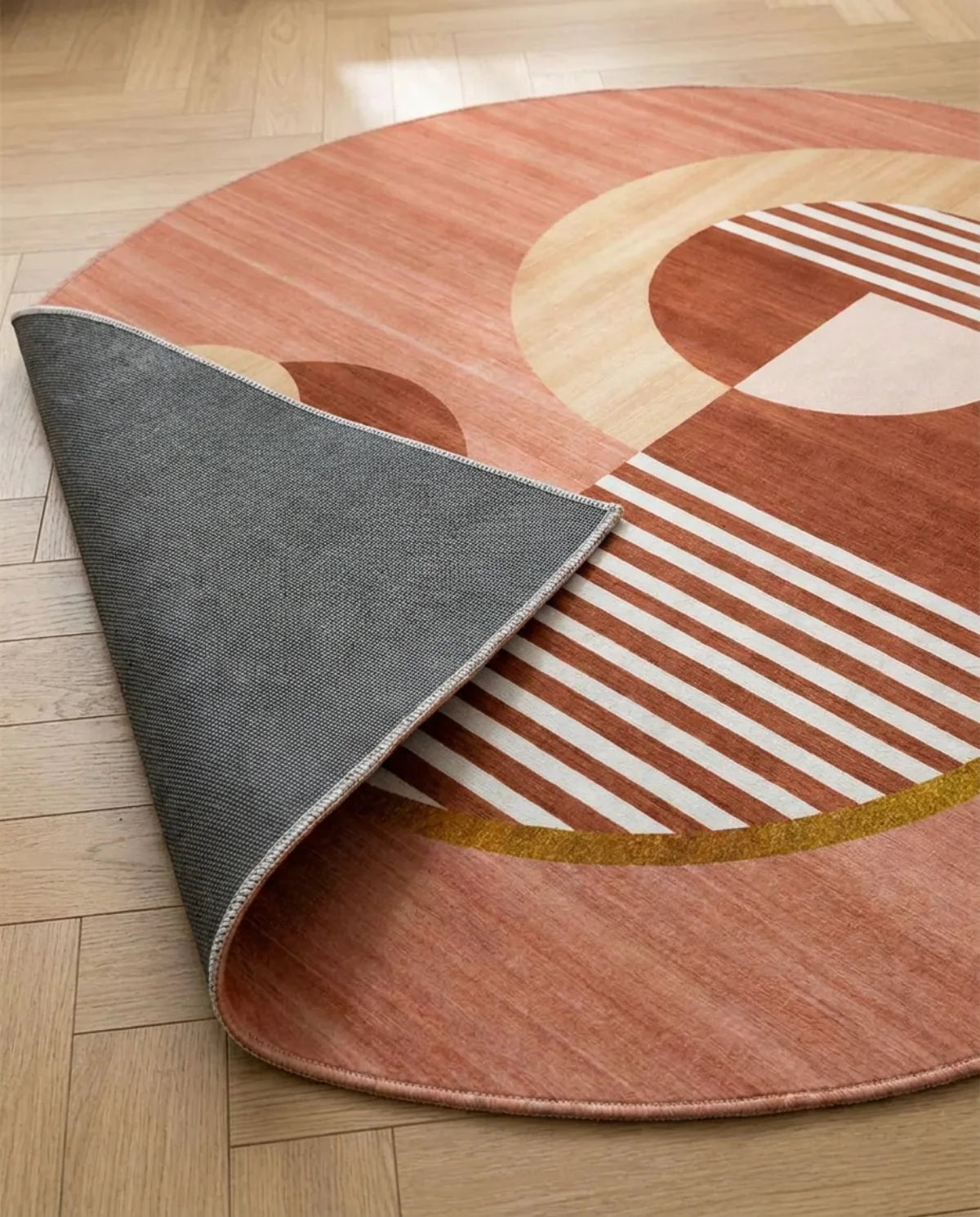 Profil fin et sous-face antidérapante du tapis rond lavable terracotta géométrique