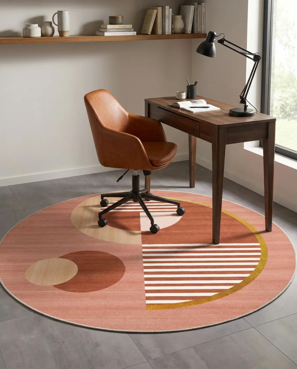 Tapis rond lavable en machine terracotta géométrique sous une chaise de bureau en cuir cognac