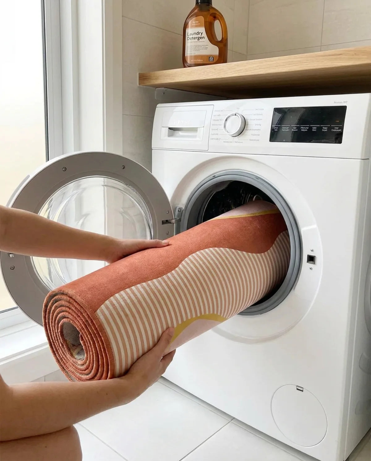 Tapis rond lavable glissé dans le tambour d'une machine à laver