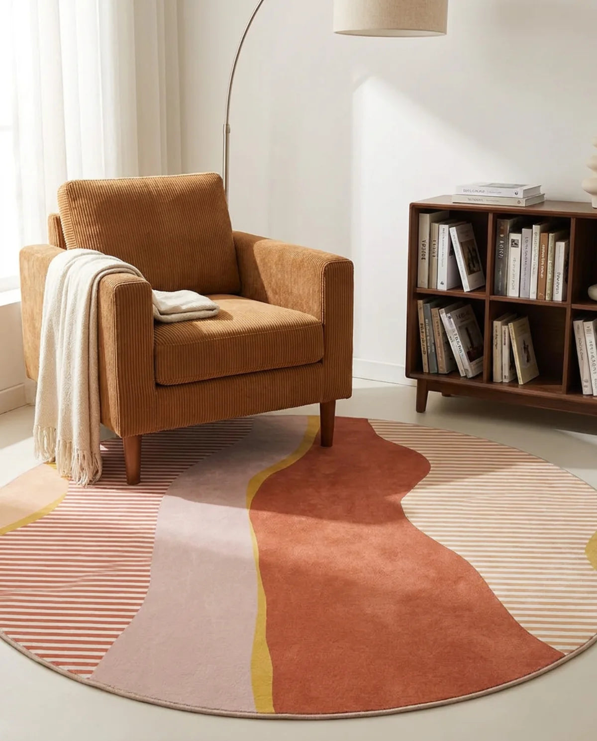 Tapis rond lavable en machine vagues terracotta dans un coin lecture au fauteuil caramel