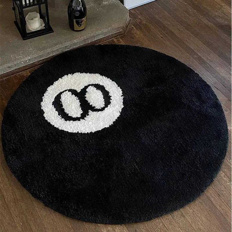 Tapis rond motif 8 ball au pied d'un lit dans une chambre étudiante