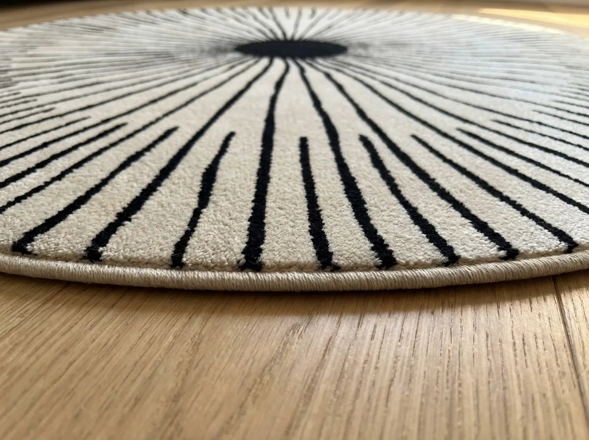 Tranche du tapis rond noir et blanc rayons soleil montrant l'épaisseur du tissage