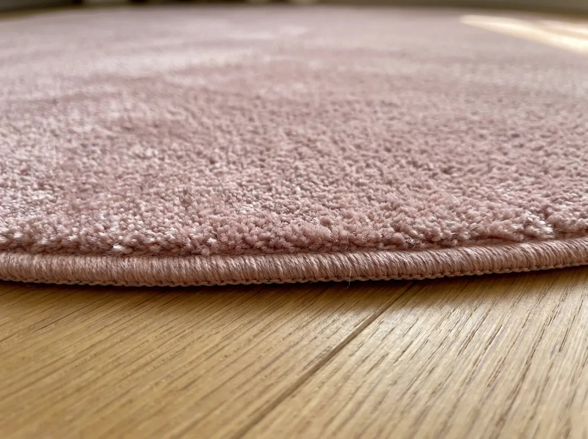 Tranche du tapis rond rose poudré peluche douce montrant l'épaisseur du tissage