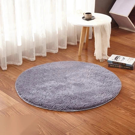 Photo originale du tapis rond moelleux gris perle dans un salon, sur parquet bois clair