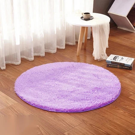 Photo originale du tapis rond moelleux mauve lavande dans un salon, sur parquet bois clair