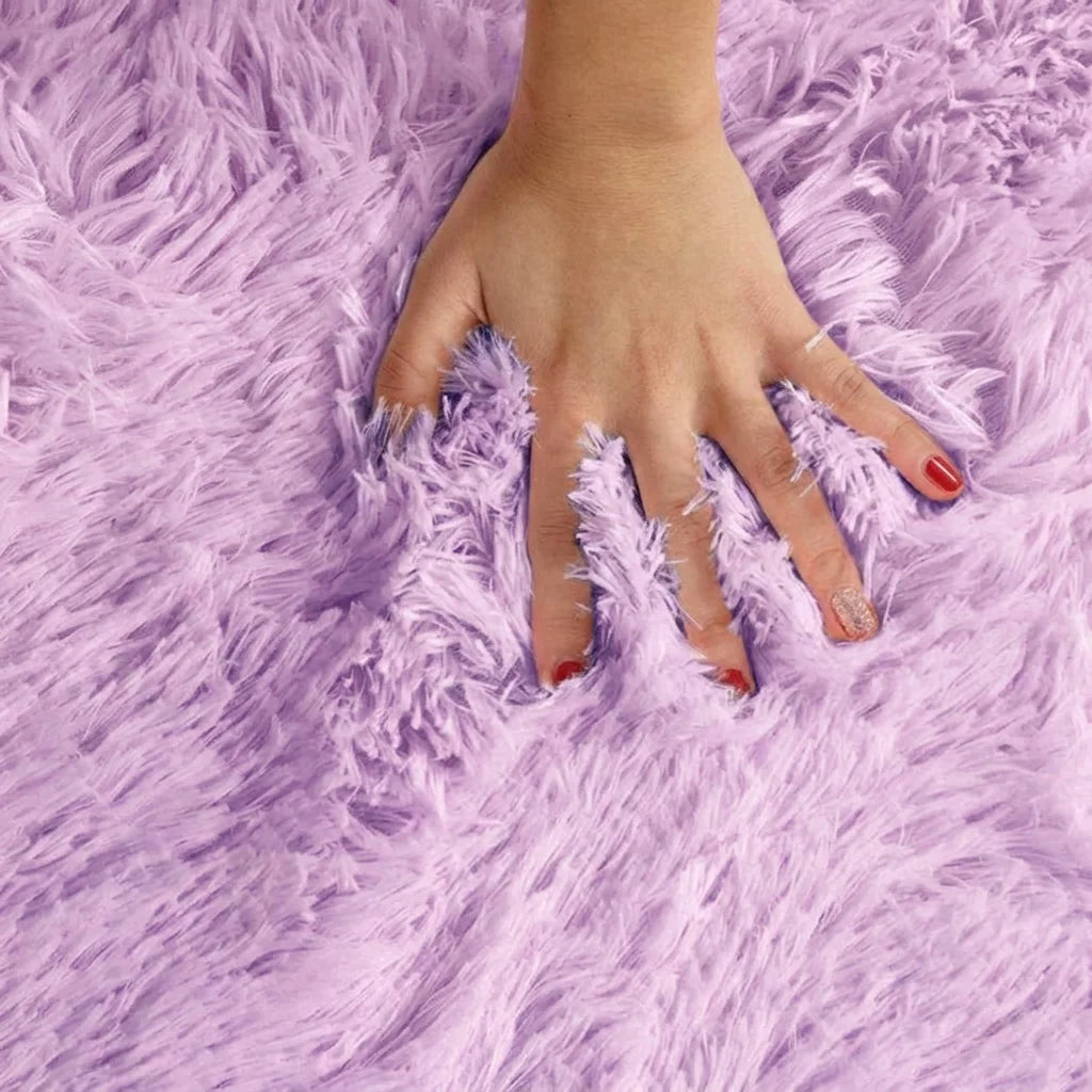 Macro de la peluche du tapis rond salle de bain moelleux mauve lavande, main posée sur les fibres longues