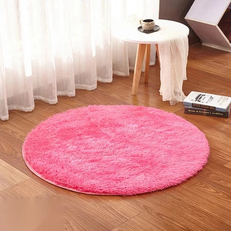 Photo originale du tapis rond moelleux rose dans un salon, sur parquet bois clair