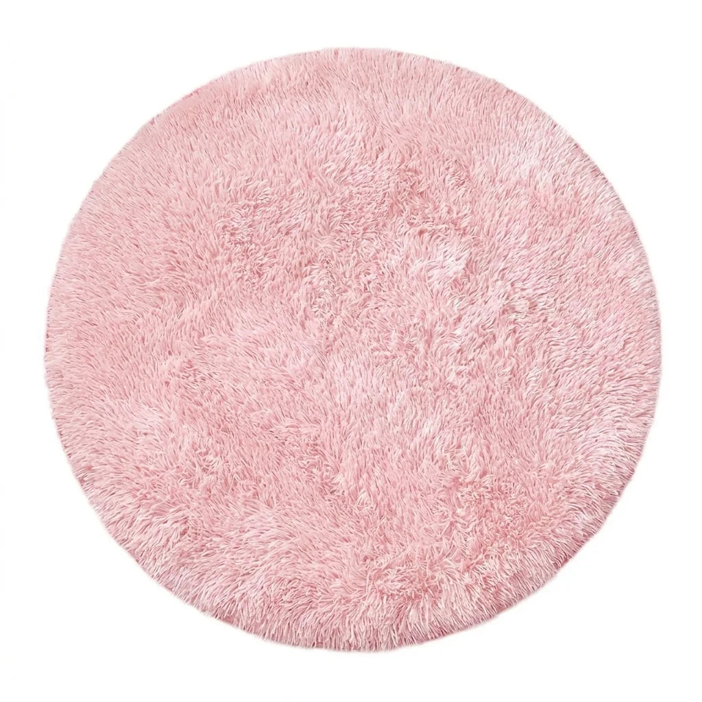 Vue studio du tapis rond salle de bain moelleux rose pâle sur fond blanc, peluche dense poil long