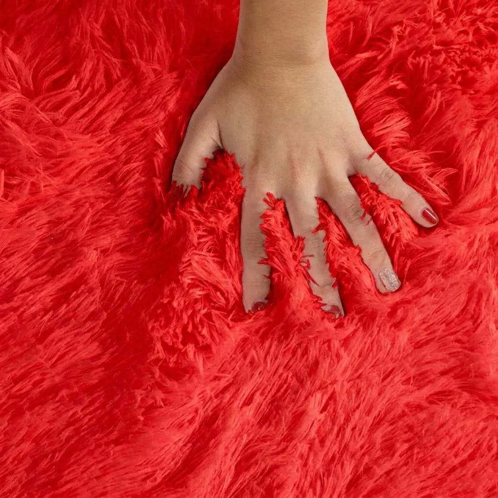 Macro de la peluche du tapis rond salle de bain moelleux rouge, main posée sur les fibres longues