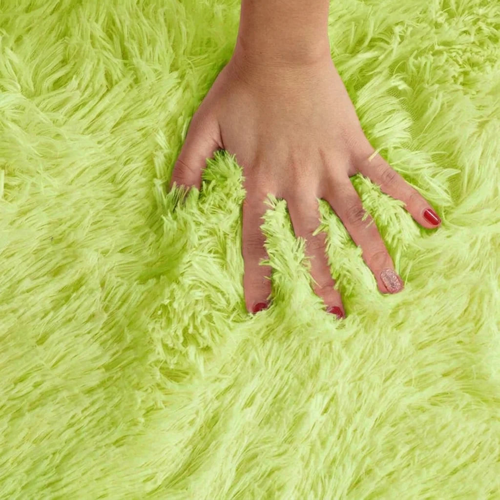 Macro de la peluche du tapis rond salle de bain moelleux vert pomme, main posée sur les fibres longues