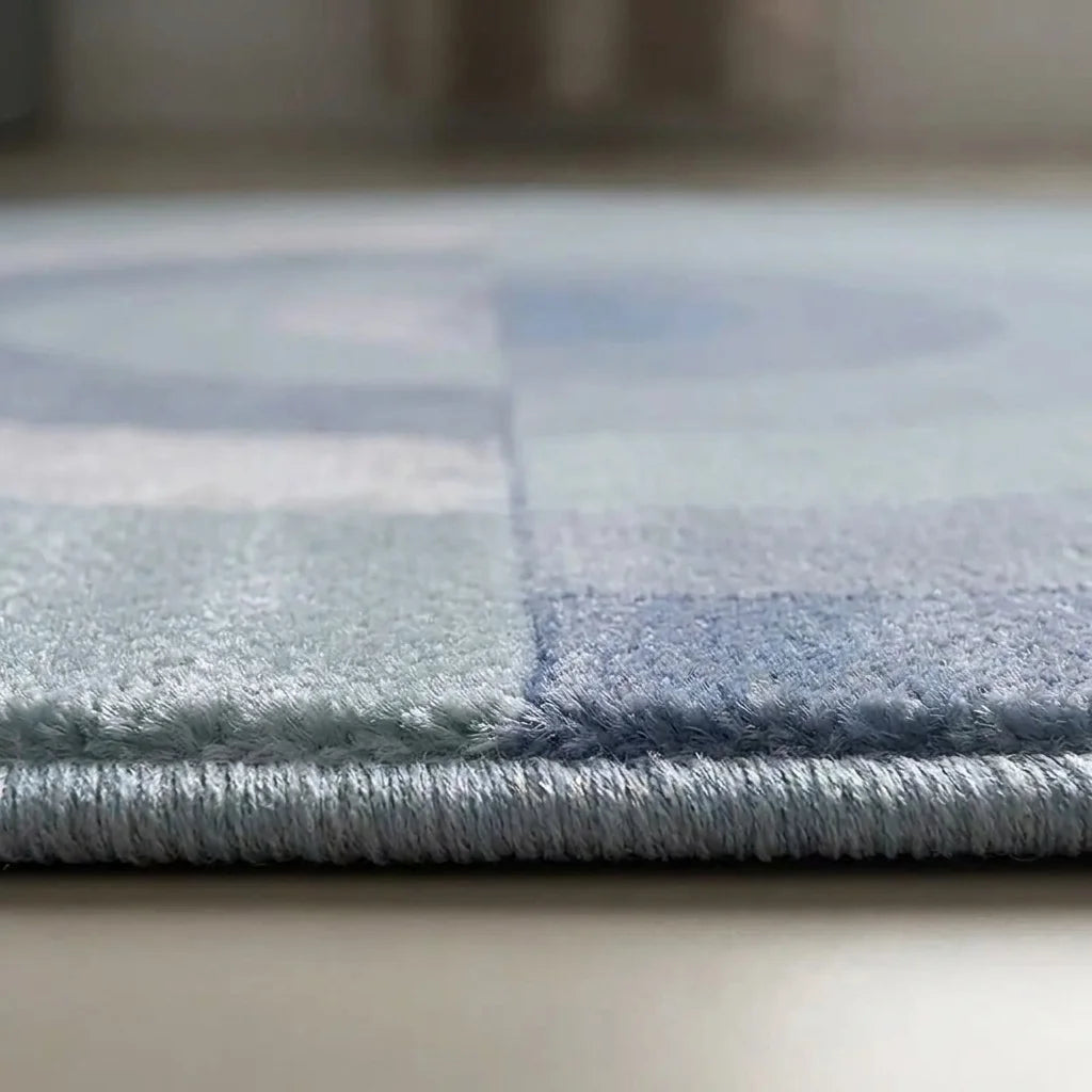 Macro du bord du tapis rond salon cercles concentriques bleu gris, épaisseur et texture peluche velours