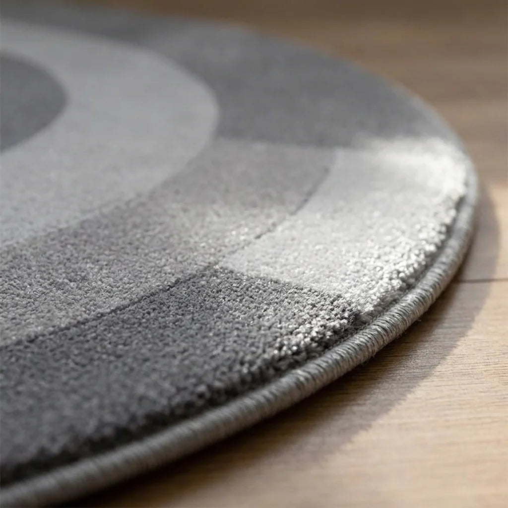 Macro du bord du tapis rond salon cercles concentriques gris, épaisseur et texture peluche velours