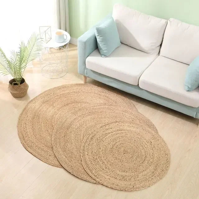 Variante nattes épaisses : tapis rond rotin dans un salon clair avec canapé vert d'eau et plante en panier