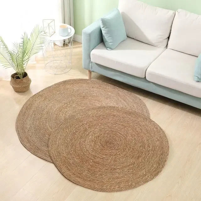 Tapis rond rotin spirale tressée dans un salon clair avec canapé vert d'eau et plante en panier osier